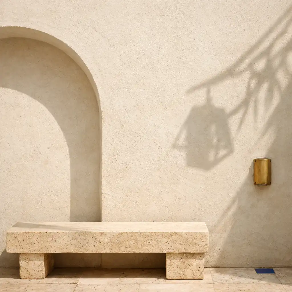 Arche de plâtre ivoire et banc en travertin dans une lumière chaude